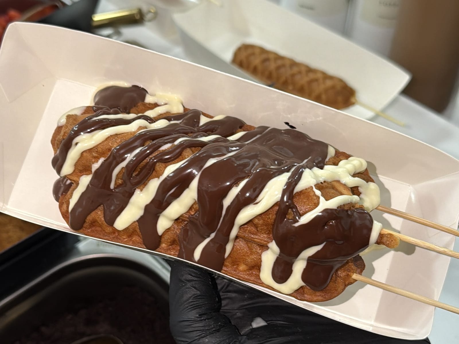 A freshly made waffle served in a tray at the Sweet St. waffle cart